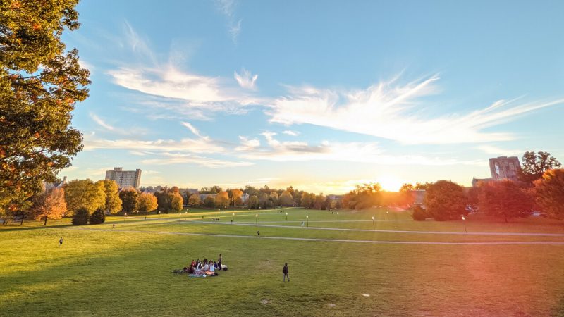 Students spread out along the Drillfield during a brilliant, sunny fall day that is nearing sundown. Photo by Christina Franusich for Virginia Tech.