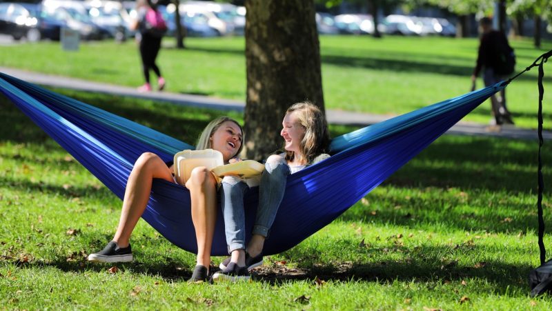 Two students hang out in a hammock on the Drillfield. Photo by Ray Meese for Virginia Tech.