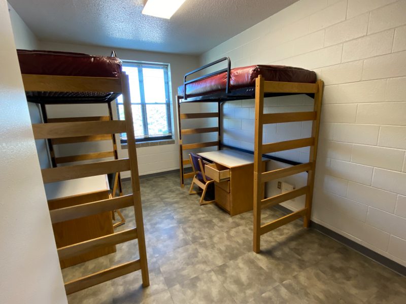 The inside of a suite-style room in Harper Hall, with two lofted beds, desks, and chairs.