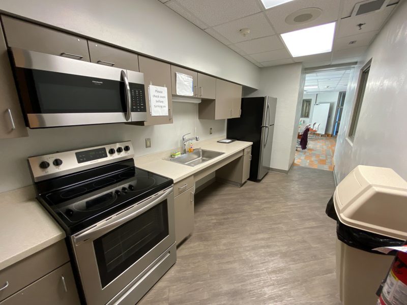 A kitchen in Campbell Hall, with fridge, microwave, and updated countertops and lighting.