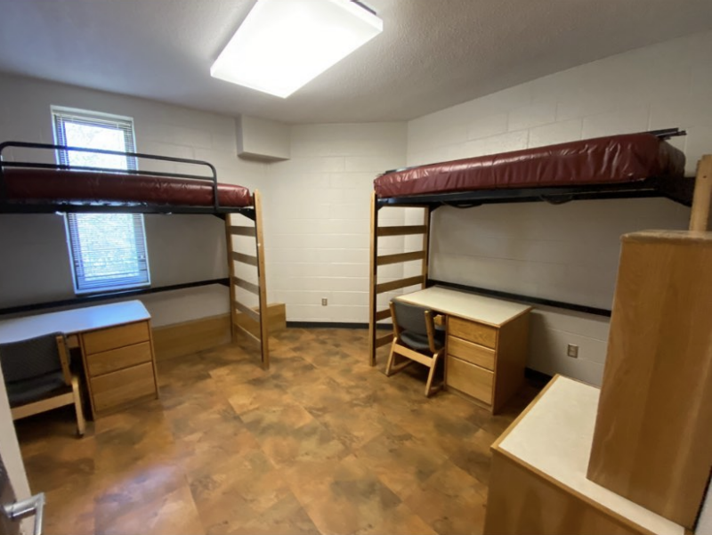 The inside of a suite-style room in New Residence Hall East, with two lofted beds, desks, and chairs.