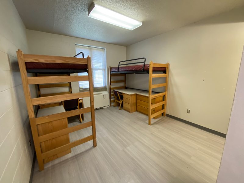 The inside of a suite-style room in Payne Hall, with two lofted beds, desks, and chairs.