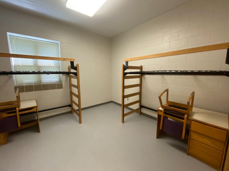 The inside of a suite-style room in Peddrew-Yates Hall, with two lofted beds, desks, and chairs.