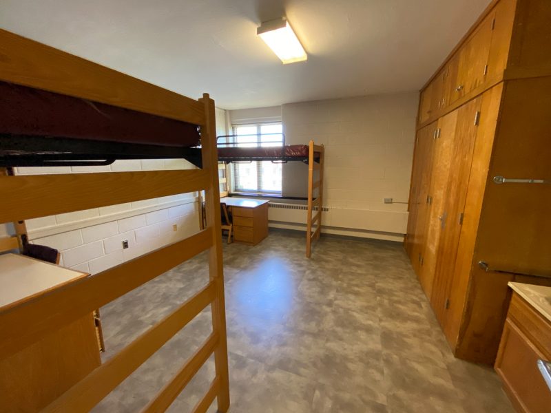 The inside of a traditional-style room in Pritchard Hall, with two lofted beds, desks, and chairs.