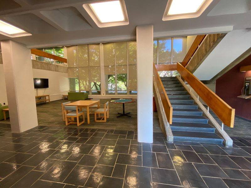A view of the tree lounge in Slusher. You can see an ascending staircase to the second floor, with chairs and a table in the large first floor space.