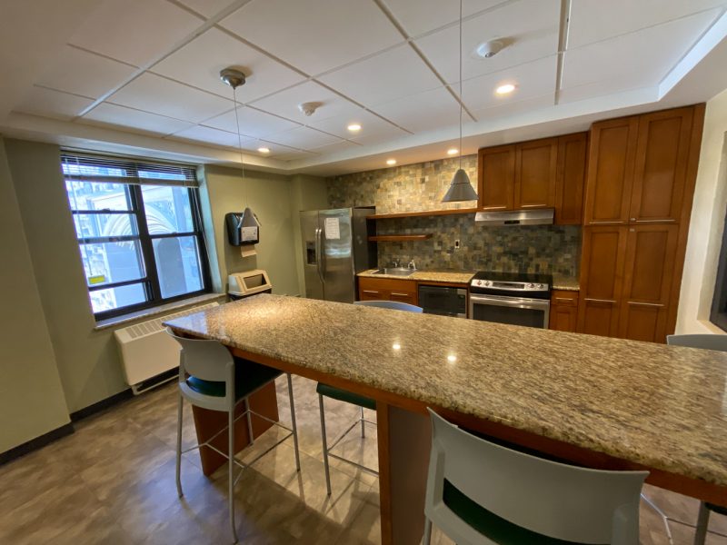 A community kitchen located in Vawter Hall, with a fridge, microwave, stove, and counter space.