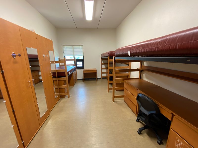 Another view into a room in Pearson Hall East, including the three beds, desks, chairs, and a view of the window.