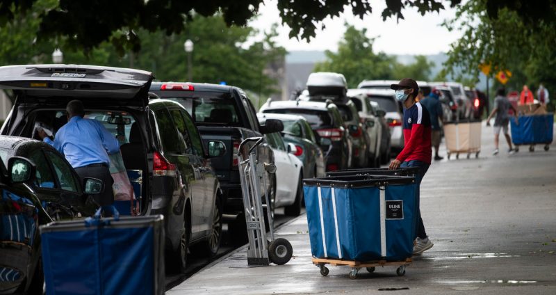 Cars line up along Washington Street, with students with carts standing ready to unload items for move-in day. Photo by Ryan Young for Virginia Tech.